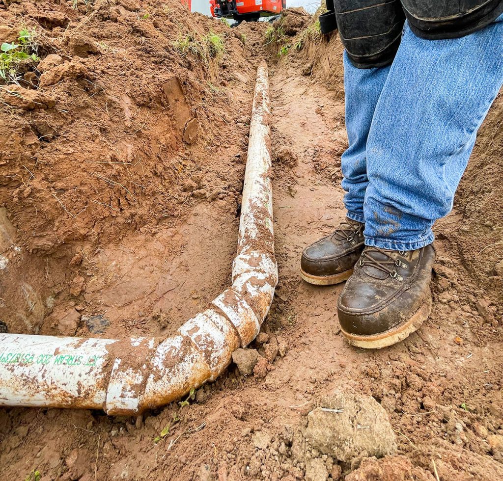 Septic technician inspecting a pipe line