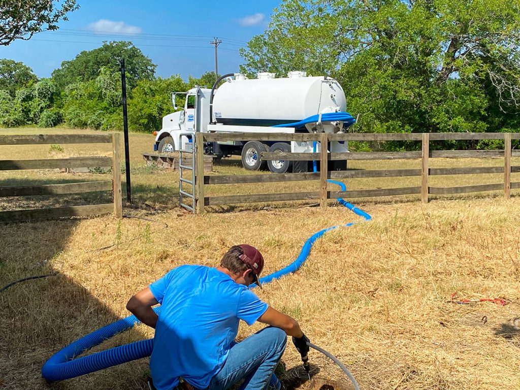 Technician pumping out septic tank